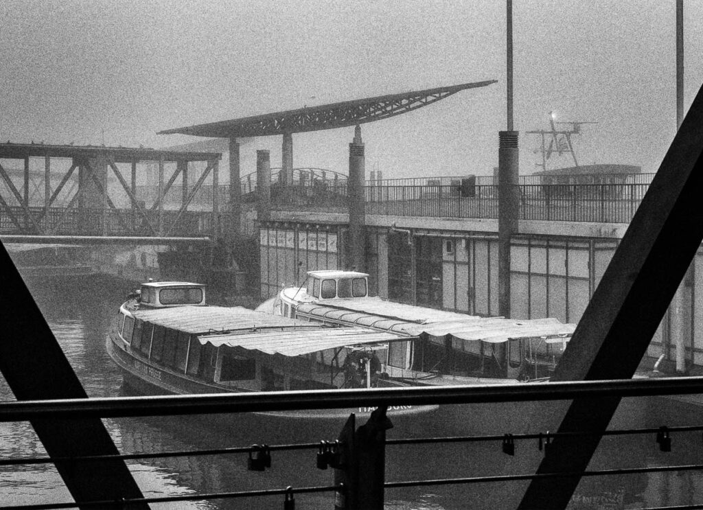 Fine-Art-Print in schwarzweiß von Barkassen im Hamburger Hafen im Morgennebel.
