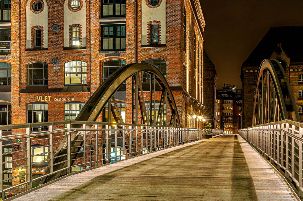Eine Fußgängerbrücke in der Speicherstadt Hamburg bei Nacht.