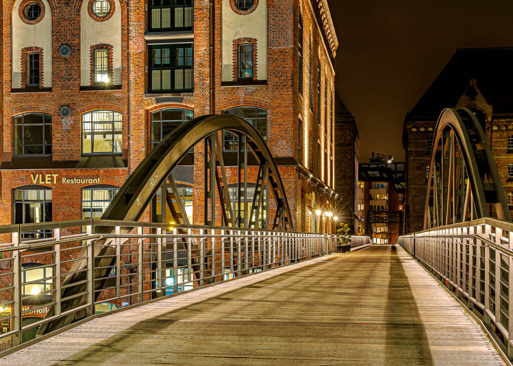 Eine Fußgängerbrücke in der Speicherstadt Hamburg bei Nacht.